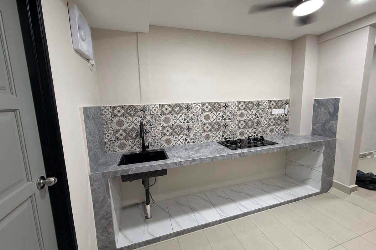 A completed kitchen with a cantilevered grey concrete-and-tile worktop, an undermounted sink, a black hob and a monochrome patterned splashback band.